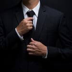 Man adjusting suit tie