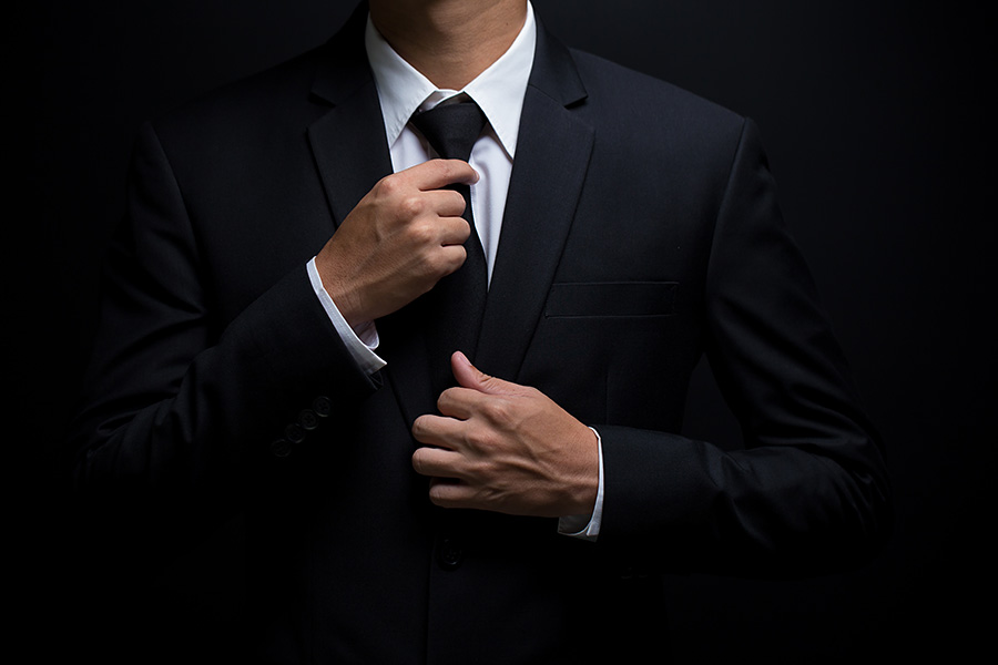 Man adjusting suit tie