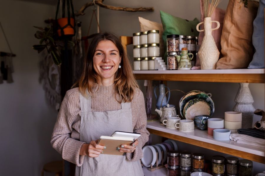 A business owner inside her shop smiles at the camera in