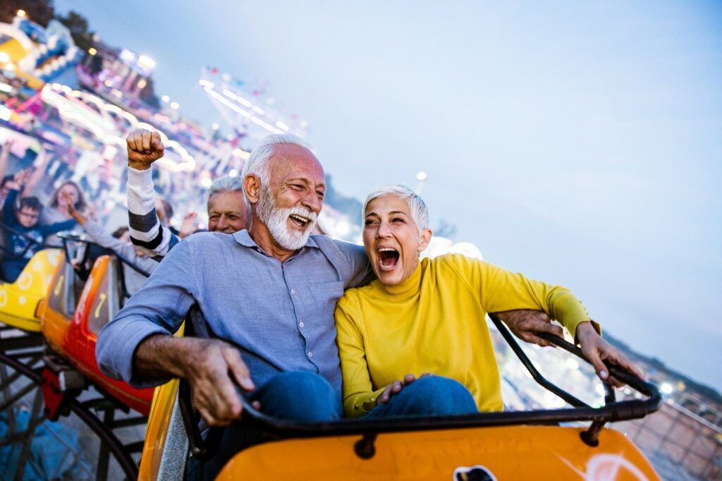 A man and a woman riding on a roller coaster